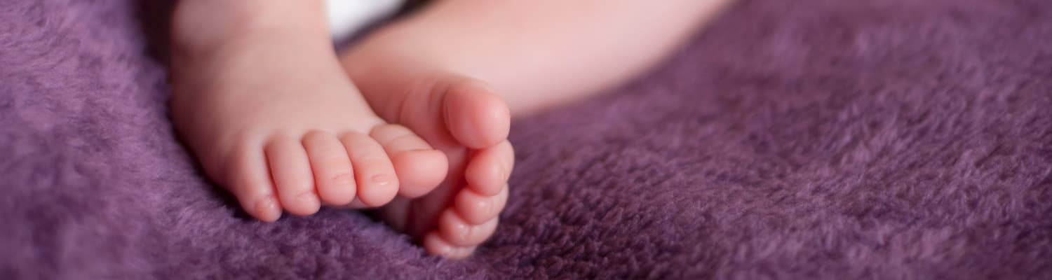 Close up of baby feet on a purple blanket
