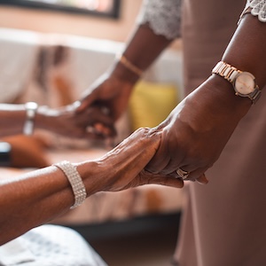 Caregiver and older patient holding hands 