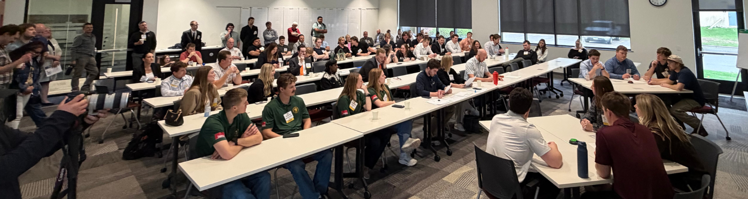 A packed room watches the Quiz Bowl competition