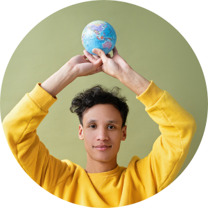 Young scholar in yellow sweatshirt holds a small globe above his head with both hands