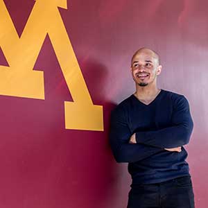 Dwayne Gibbs in front of maroon wall