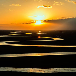  image of a river winding beneath a sunset