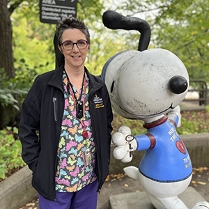 Janet Nelson stands beside the Snoopy statue outside the U of M Veterinary Medical Center