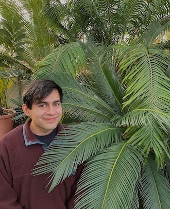 Jesús Trujillo next to large fern