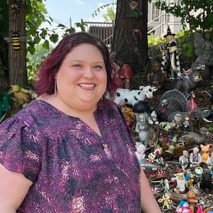 Laura Krider stands in front of a display of old toys and knick knacks