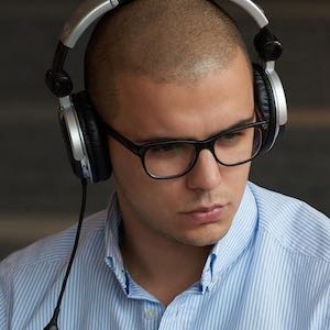 Man wearing headset working on two computers