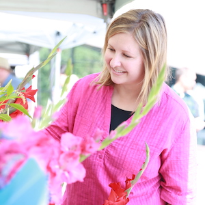 Terri Schlegel-David looking at gladiola flowers at farmer's market