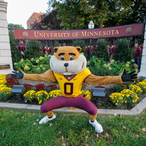 Goldy the Golden Gopher welcomes people in front of U of M sign