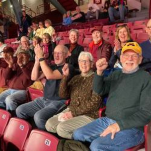 A group of U of M retirees attend a Gopher game and cheer from the stands