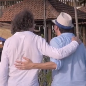 Two men walking arm in arm