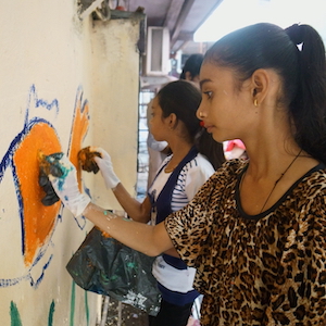 Two young people painting a mural