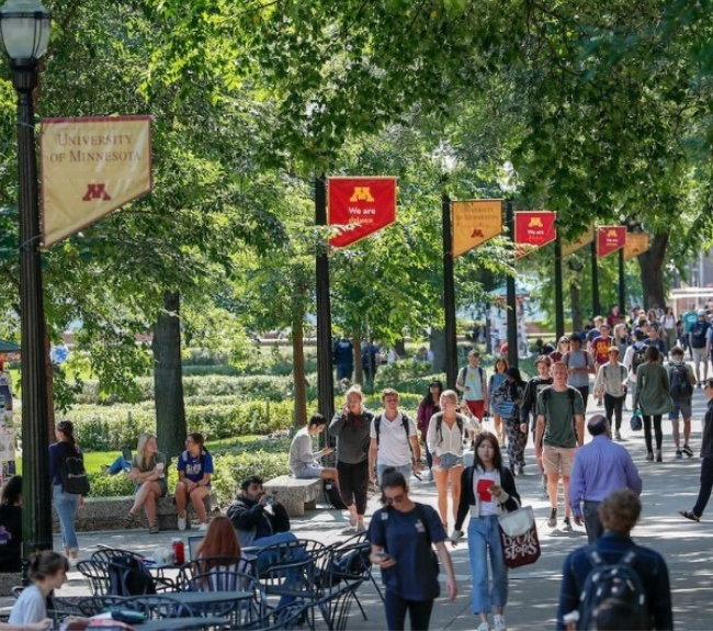 Dozens of people wall along Northrop Mall on a spring day