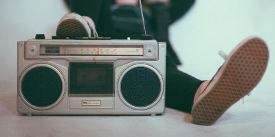 A young person lounges by an old-school boombox