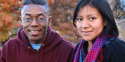 one black male student with glasses with a brown skinned woman