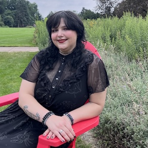 Kendra White seated on a red Adirondack chair