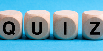The word QUIZ spelled out with die on a blue background