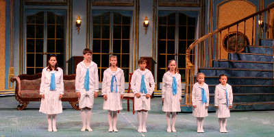A row of child actors on stage performing the Sound of Music