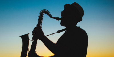 silhouette of a jazz saxophonist against a sunrise