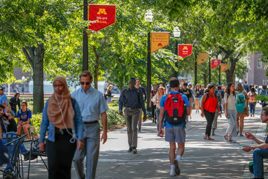 Dozens of students walk along Northrop Mall in summer