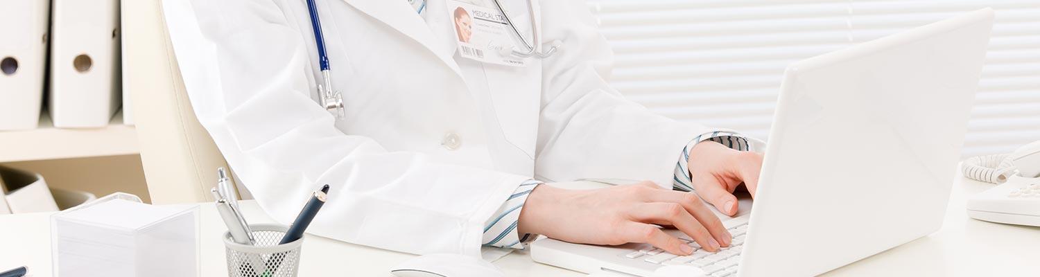 image of a doctor typing notes in a laptop