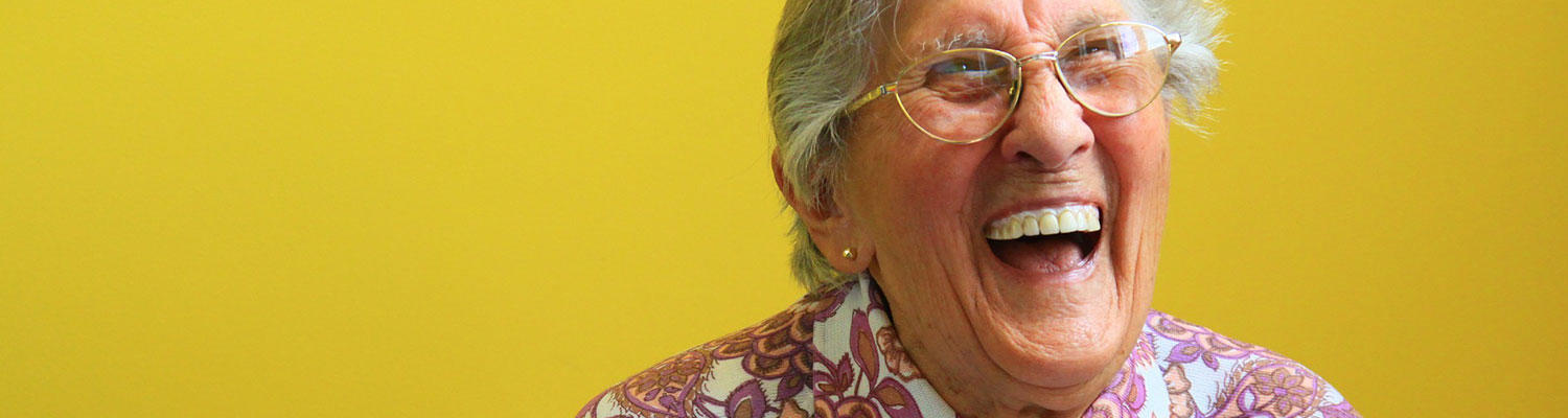 An older woman is laughing.