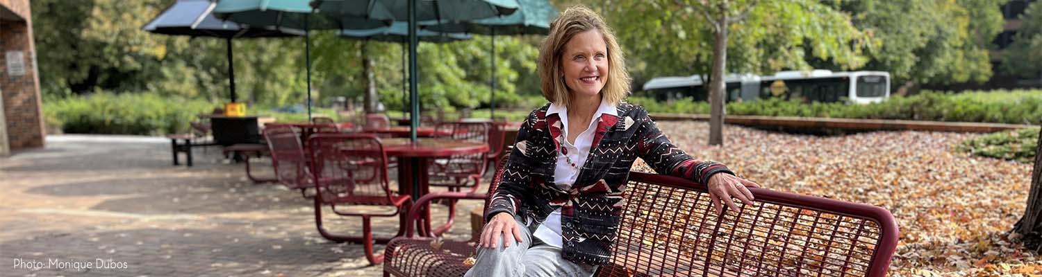 Beth Lory relaxes on a maroon bench in front of the Student Center on the U of M St. Paul campus