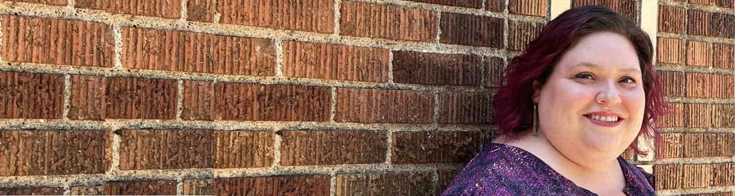 Laura Krider stands in front of a brick wall