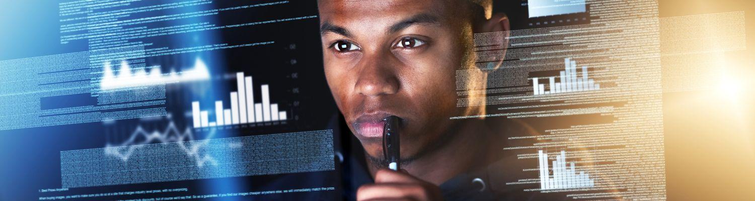 A Black man studying digital information and charts
