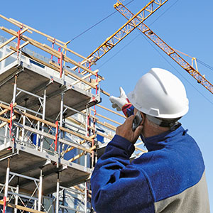 man in hardhat point to a building construction site